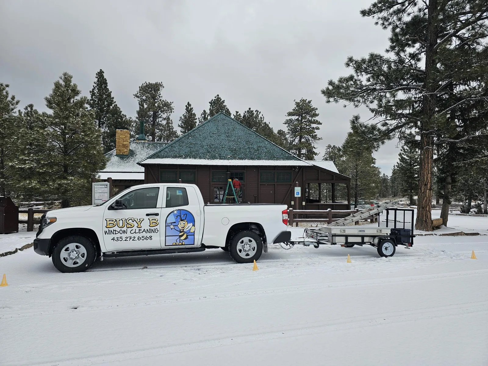 The Busy B truck and trailer parked at a snowy lodge.