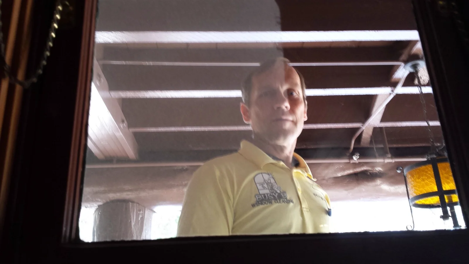 Jim seen through a window while working on the glass